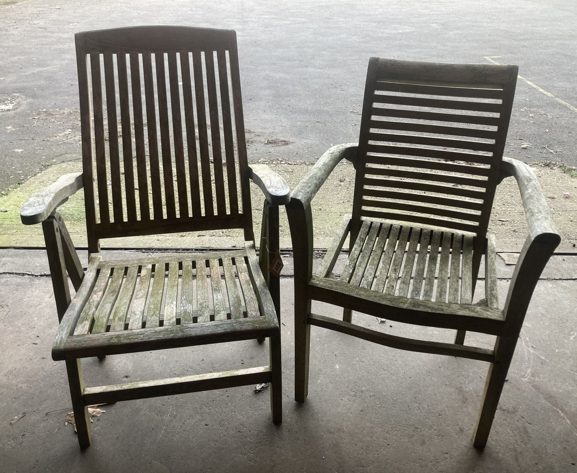 A weathered teak folding garden armchair, together with a teak garden elbow chair